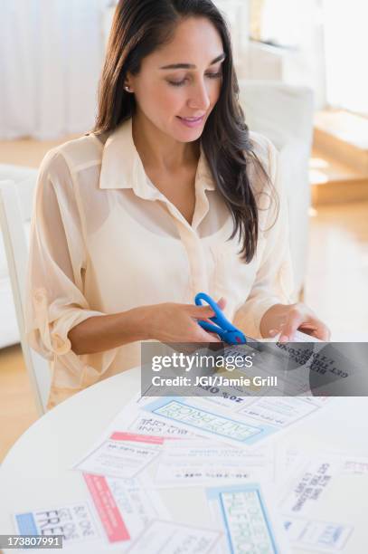 caucasian woman clipping coupons - budget cuts stock-fotos und bilder