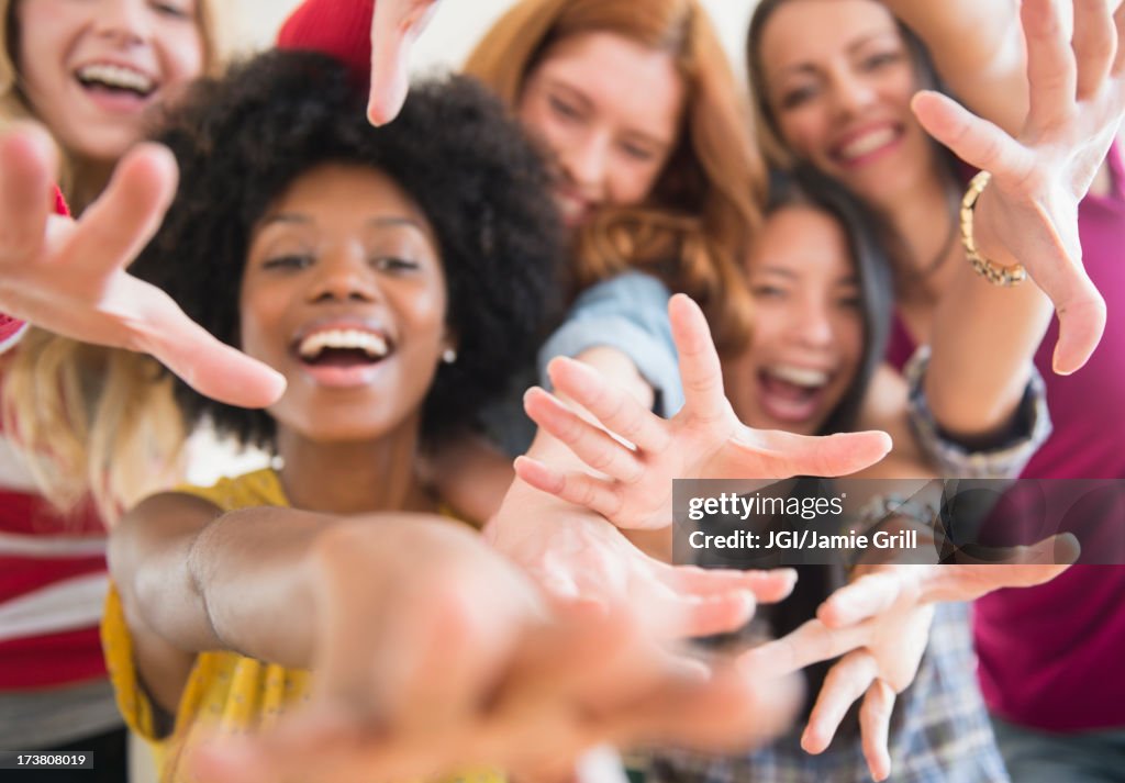 Smiling women reaching forward