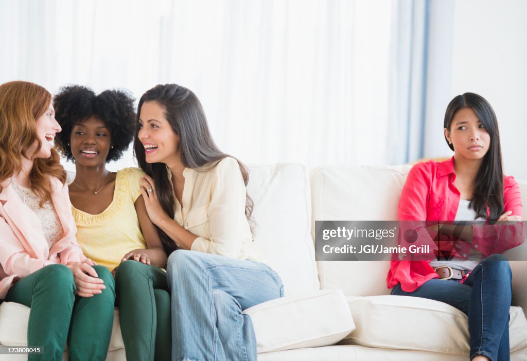 Woman excluded from conversation on sofa