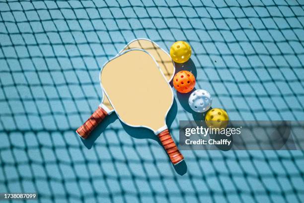 adults playing pickleball on a public court - racket stock pictures, royalty-free photos & images