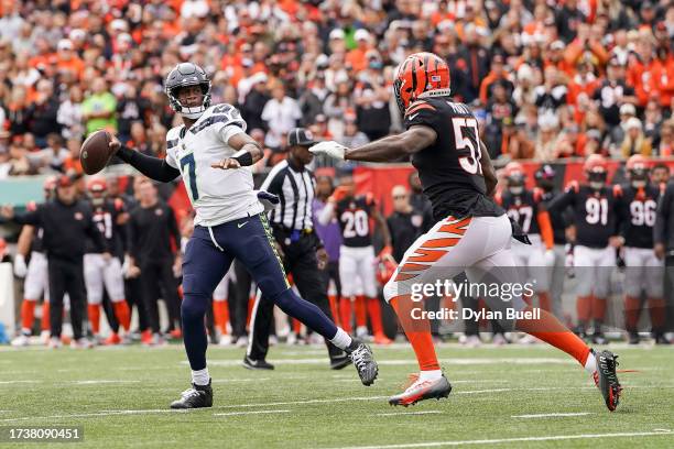 Geno Smith of the Seattle Seahawks throws a pass while being chased by Germaine Pratt of the Cincinnati Bengals in the first quarter at Paycor...