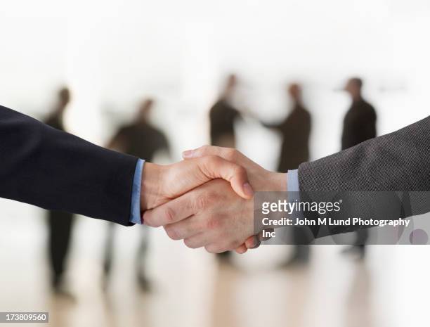 close up of businessmen shaking hands - handshake close up stock-fotos und bilder