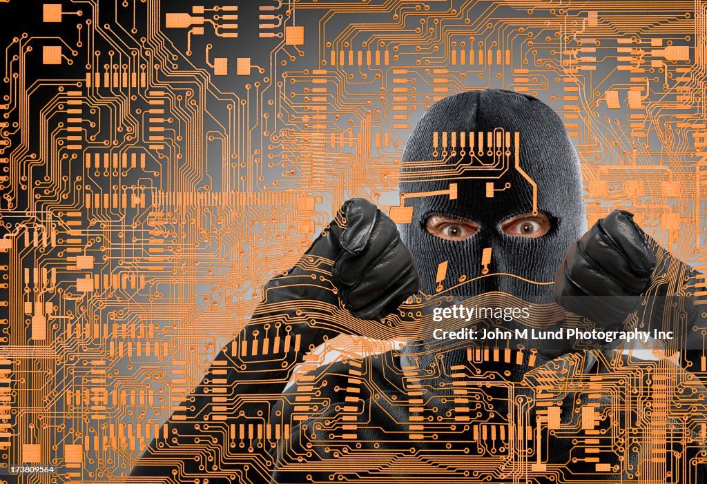 Caucasian man in ski mask behind microchip pattern