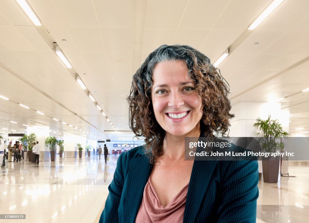 Hispanic businesswoman smiling in office