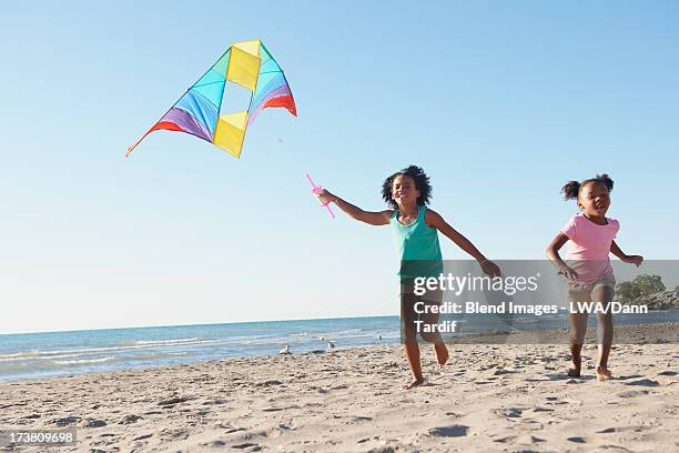 black girls flying kites on beach - kite flying stock pictures, royalty-free photos & images