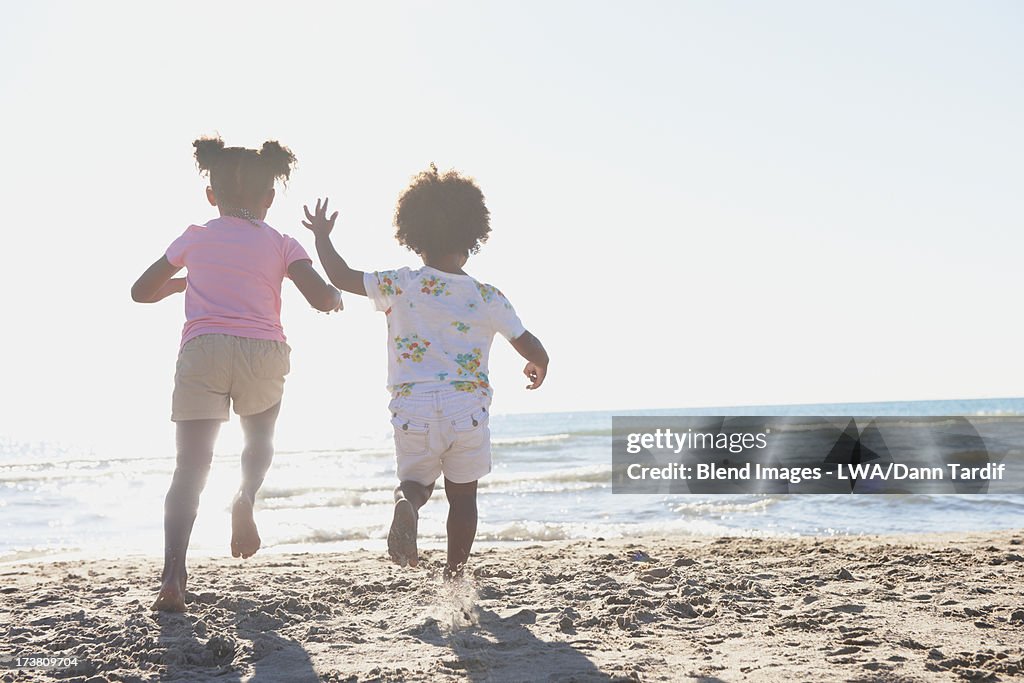 Black girls running on beach