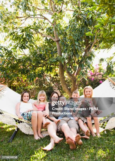 caucasian children sitting in hammock - familie mit vier kindern stock-fotos und bilder