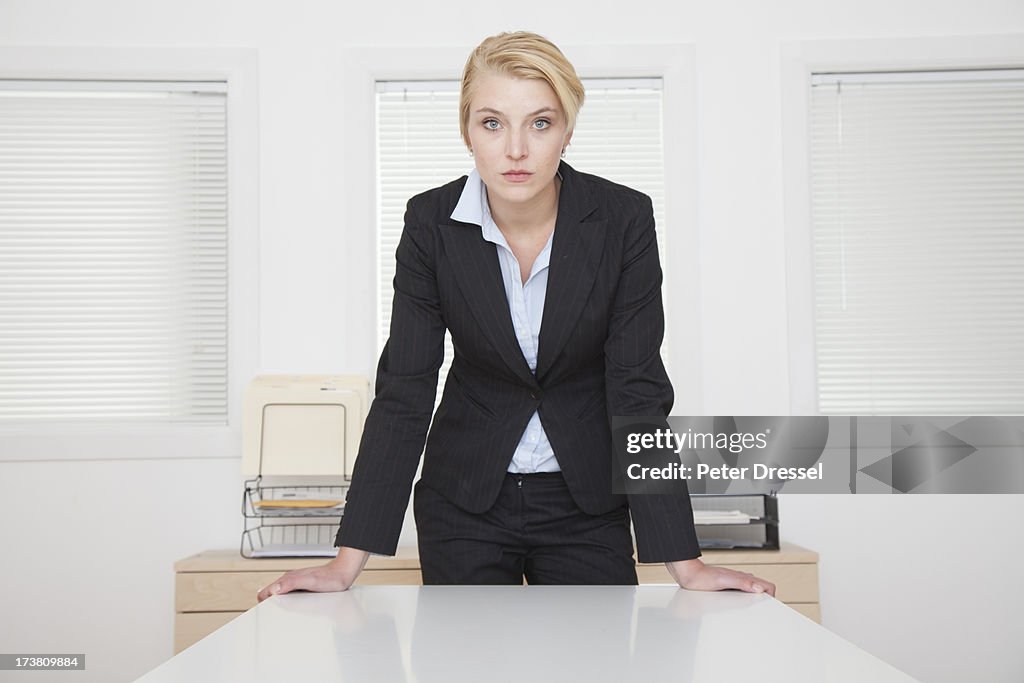 Caucasian businesswoman standing at desk in office