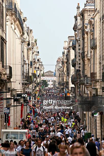 Pedestrians pass along Rue Sainte-Catherine, the main shopping street in Bordeaux, France, on Wednesday, July 17, 2013. Austerity measures and rising...