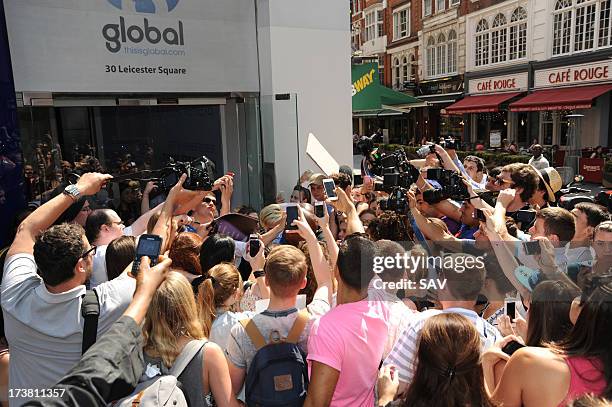 Miley Cyrus is hounded by photographers and fans outside the Capital radio studios in Leicester square on July 18, 2013 in London, England.