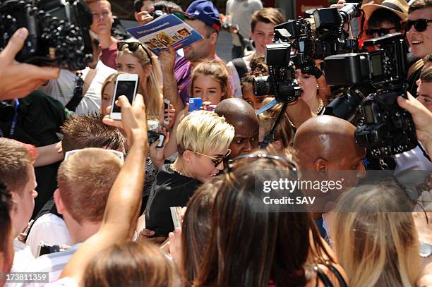 Miley Cyrus is hounded by photographers and fans outside the Capital radio studios in Leicester square on July 18, 2013 in London, England.