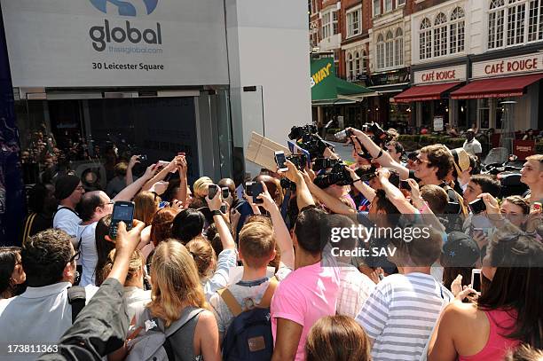 Miley Cyrus is hounded by photographers and fans outside the Capital radio studios in Leicester square on July 18, 2013 in London, England.