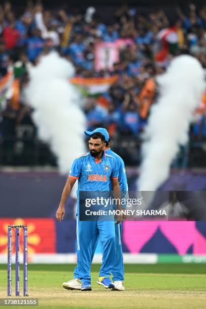 India's Mohammed Shami gestures after taking the wicket of New Zealand's Rachin Ravindra during the 2023 ICC Men's Cricket World Cup one-day...