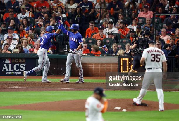 Leody Taveras of the Texas Rangers celebrates his solo home run against the Houston Astros with Marcus Semien in the fourth inning during Game One of...