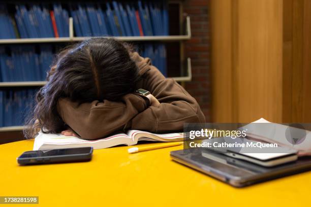 multiracial female student takes a rest while studying in school library - ensino superior imagens e fotografias de stock