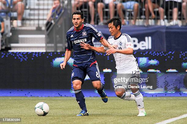 Dilly Duka of Chicago Fire chases the ball against Young-Pyo Lee of the Vancouver Whitecaps during an MLS Match at B.C. Place on July 14, 2013 in...