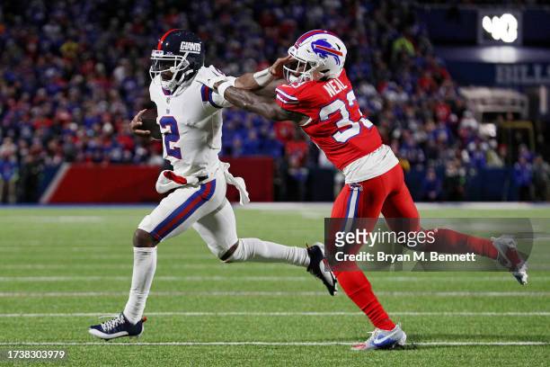 Tyrod Taylor of the New York Giants runs out of bounds as Siran Neal of the Buffalo Bills chases in the fourth quarter of a game at Highmark Stadium...