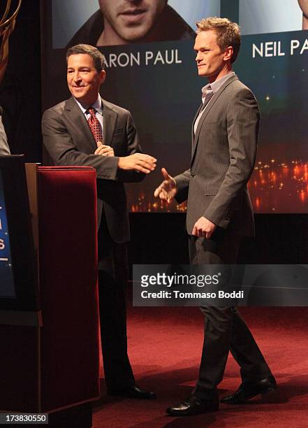 Actor Neil Patrick Harris walks onstage to join Academy of Television Arts & Sciences Chairman & CEO Bruce Rosenblum during the 65th Primetime Emmy...