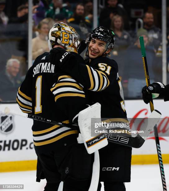 Jeremy Swayman of the Boston Bruins and teammate Matthew Poitras celebrate a 3-2 victory against the Nashville Predators at the TD Garden on October...