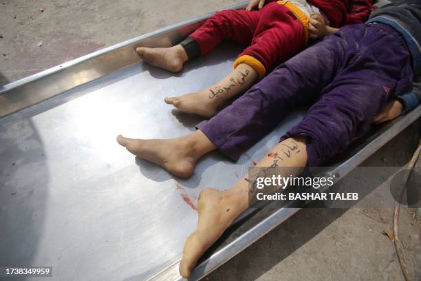 Graphic content / TOPSHOT - The bodies of children from the Nateel family, with their names Hani and Layan written on their legs by their parents to...