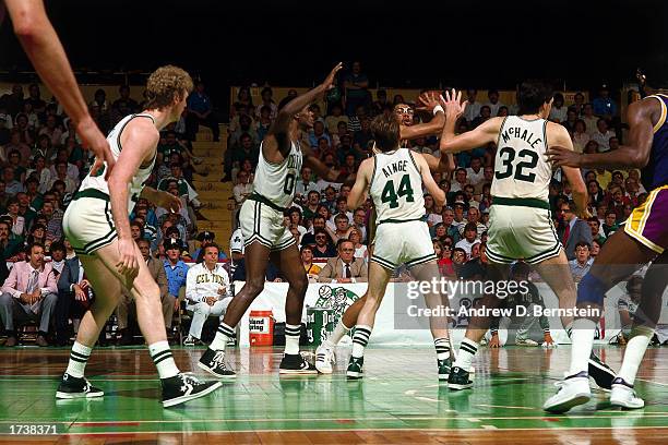 Kareem Abdul-Jabbar of the Los Angeles Lakers looks to make a pass while being defended by Larry Bird, Robert Parish, Danny Ainge and Kevin McHale of...