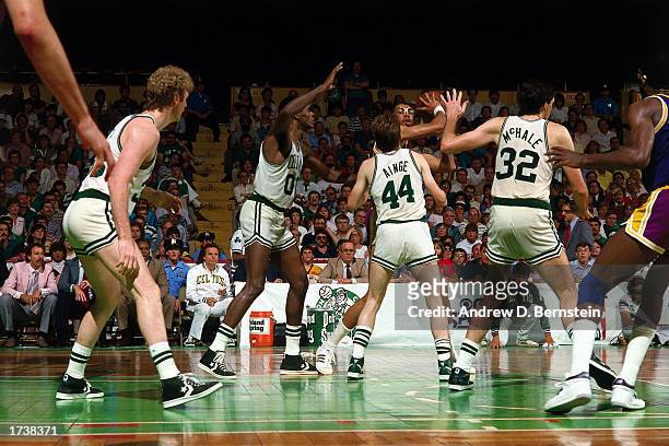 Kareem Abdul-Jabbar of the Los Angeles Lakers looks to make a pass while being defended by Larry Bird, Robert Parish, Danny Ainge and Kevin McHale of...