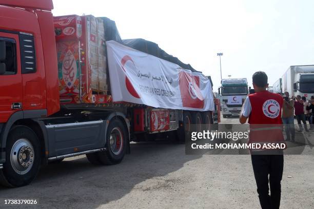 Volunteer from the Egyptian Red Crescent looks on as a convoy of lorries carrying humanitarian aid crosses to the Gaza Strip on October 22, 2023. The...