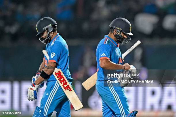 India's Virat Kohli arrives to bat as team's captain Rohit Sharma walks back to the pavilion after his dismissal during the 2023 ICC Men's Cricket...