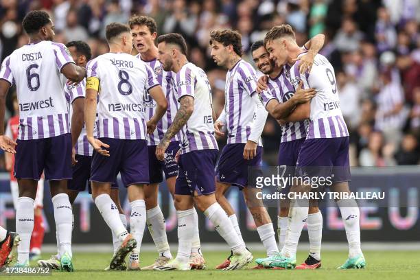 Toulouse's Dutch forward Thijs Dallinga is congratulated by Toulouse's Chilean defender Gabriel Suazo after he scored a first goal for his team...