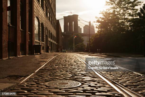 deserted brooklyn dumbo cobblestone backstreet sunset lens flare - brooklyn new york stockfoto's en -beelden