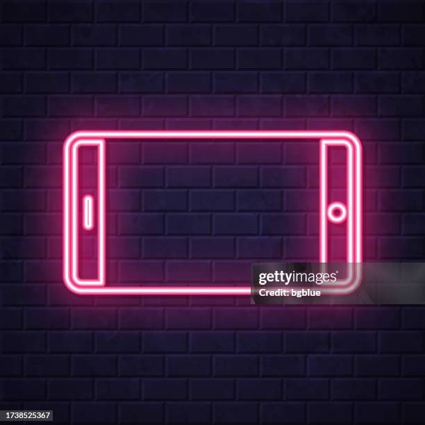 smartphone - horizontal position. glowing neon icon on brick wall background - touch screen wall stock illustrations