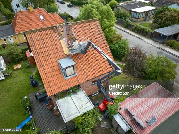 boom lift, fixing chimney on old house - handyman stock pictures, royalty-free photos & images