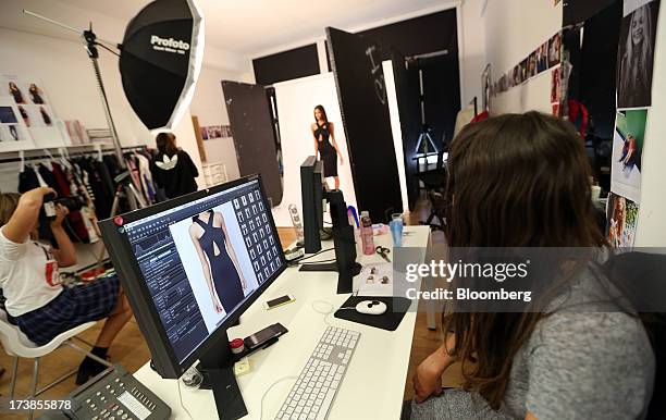 Photo editor watches as a model poses during a photo shoot at the headquarters of Asos Plc in London, U.K., on Wednesday, July 17, 2013. Asos Plc,...