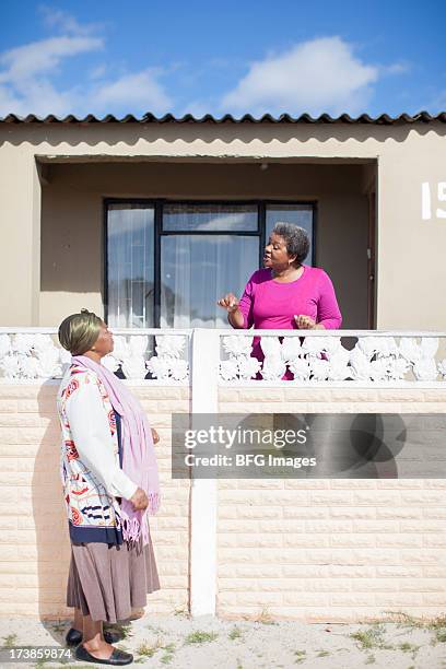 dos mujeres charlar junto a la valla, ciudad del cabo, sudáfrica - south africa women fotografías e imágenes de stock