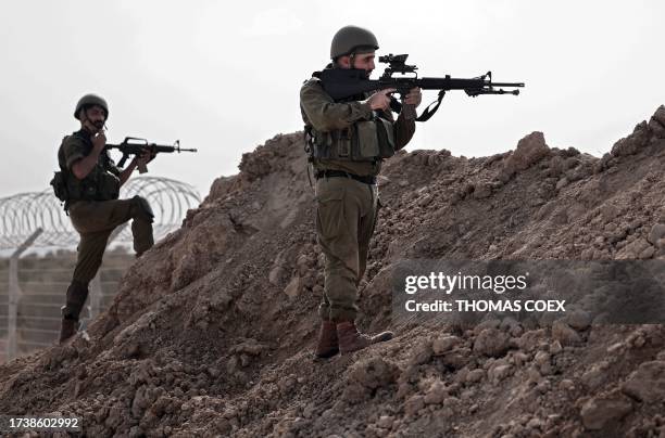 In this picture taken during a media tour organised by the Israeli military on October 22 Israeli soldiers take a defensive position in Kibbutz Beeri...