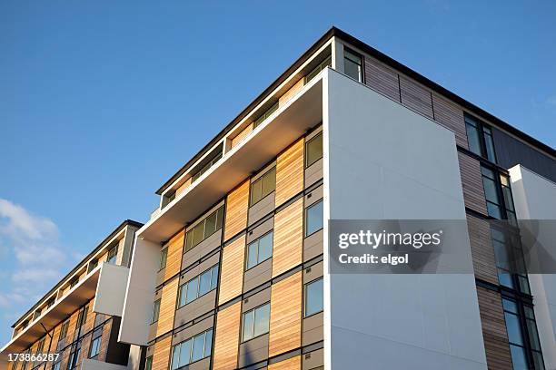 residential apartment mit holzvertäfelung und blau clear sky - modern apartment exterior stock-fotos und bilder