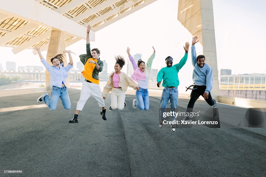 Community Having Fun Group Of Multiracial Young Friends Having Fun Jumping Together Over ...