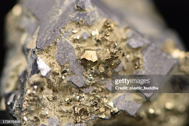 macro picture of a raw golden nugget found on a mine - zuiverheid stockfoto's en -beelden