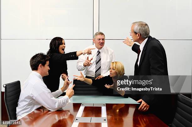 agitated business people at a meeting pointing at each other - vechten stockfoto's en -beelden