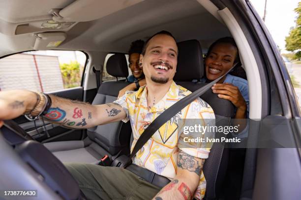 happy taxi driver driving his black customers in a car. - car pooling stock pictures, royalty-free photos & images