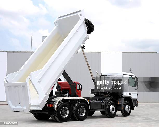 a brand new dump truck lifted up for view - dump truck stock pictures, royalty-free photos & images