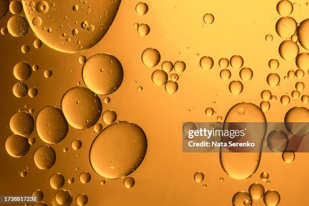 oil with bubbles on orange monochrome background - oil flow stockfoto's en -beelden