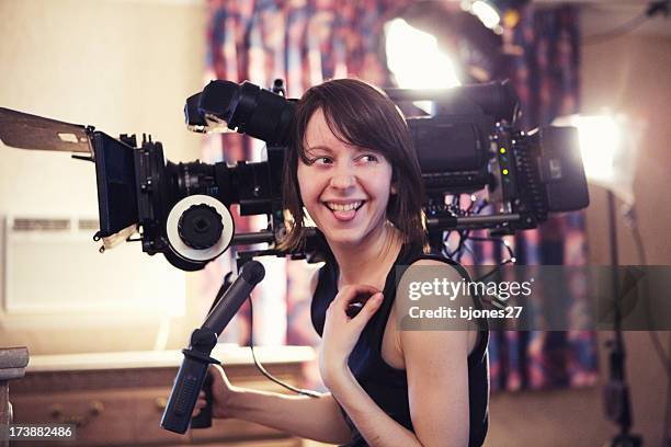 mujer sonriente con cámara - realizador de cinema fotografías e imágenes de stock