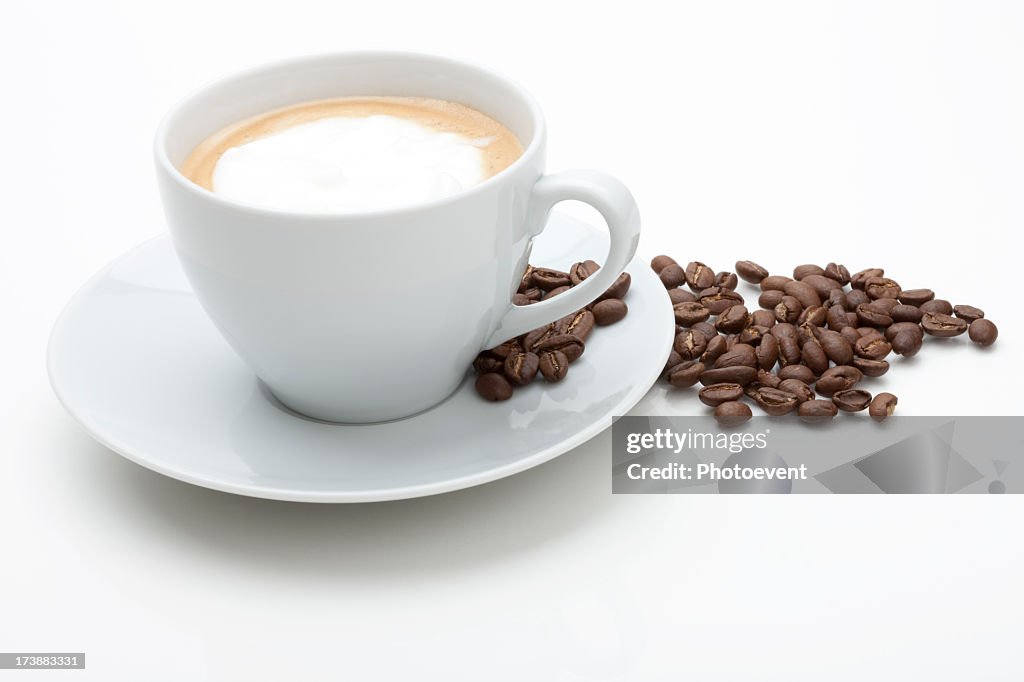Cappuccino with fresh coffee beans in white background
