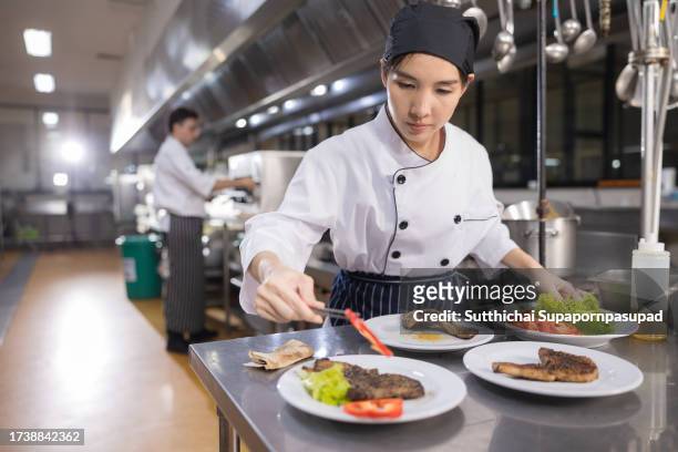 the art of presentation: female chef creates visual masterpieces with food plate decor in the kitchen" - accompagnement professionnel photos et images de collection