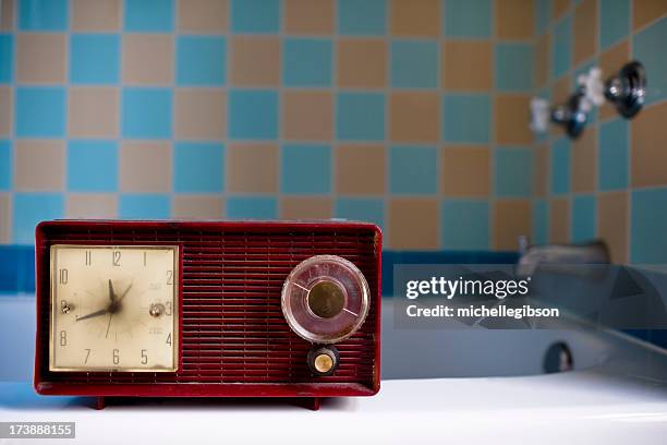 red vintage retro radio sitting on bath tub ledge - personal stereo stockfoto's en -beelden