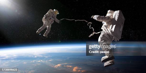 two astronauts on tethered spacewalk facing each other - gravidade zero imagens e fotografias de stock