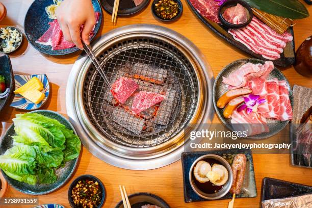 grilling raw beef on a korean barbecue grill - multi fuel stoves stock pictures, royalty-free photos & images