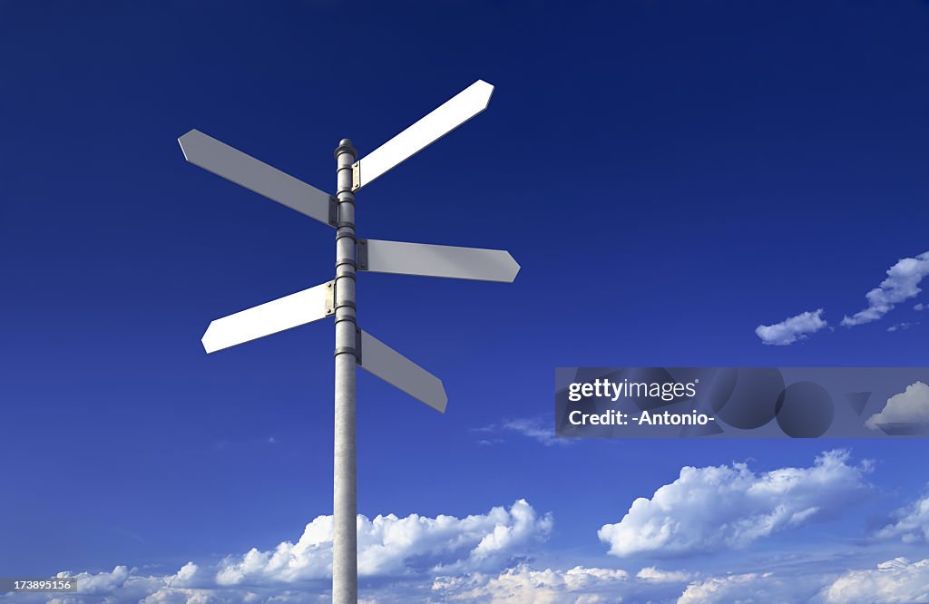 Signpost with three blank signs on sky backgrounds