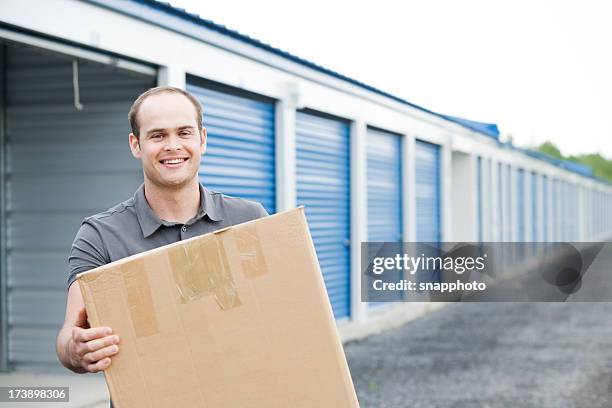 man holding box outside self storage unit - compartment stock pictures, royalty-free photos & images